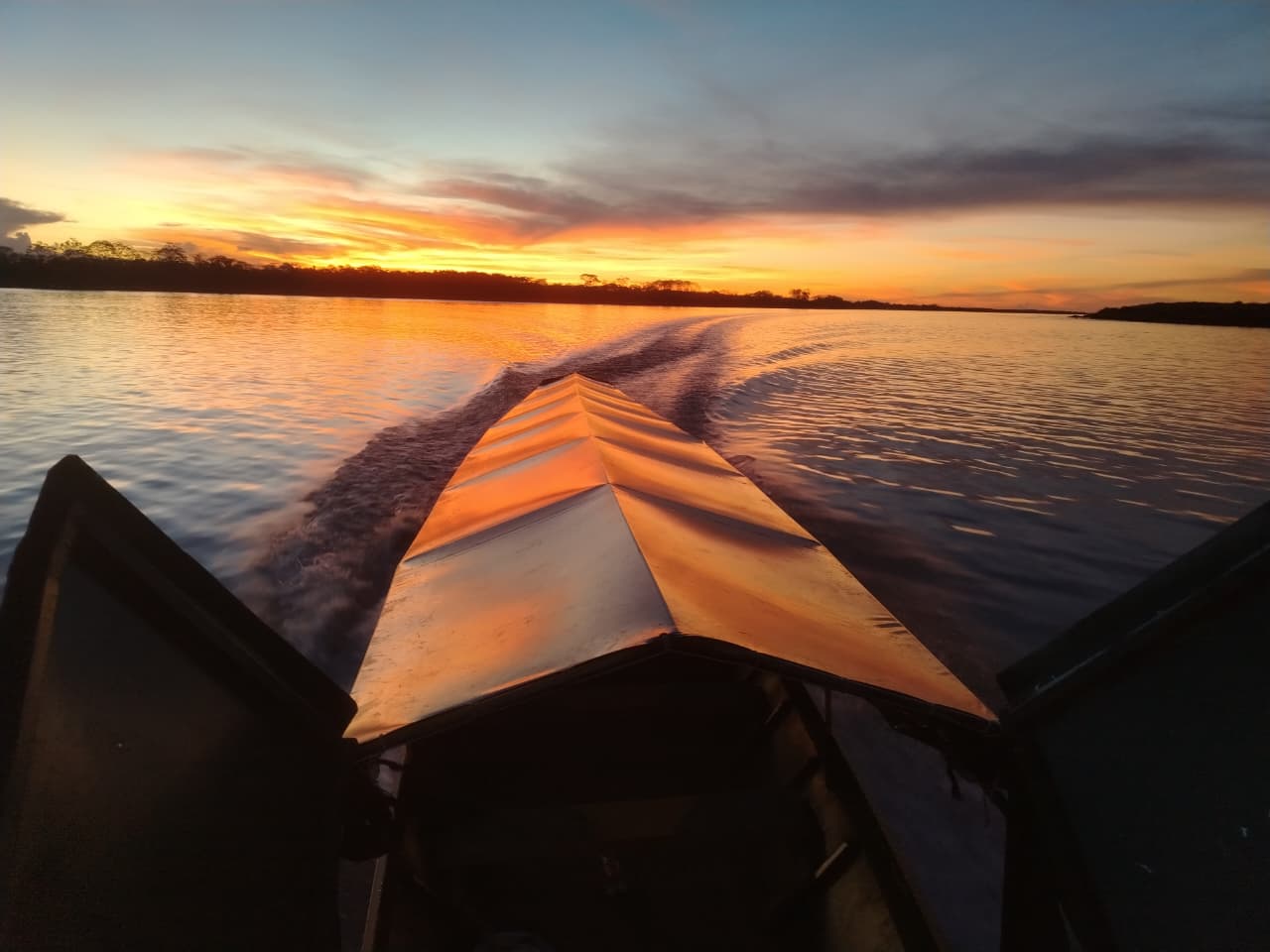 Bote navegando en el río amazónico al atardecer